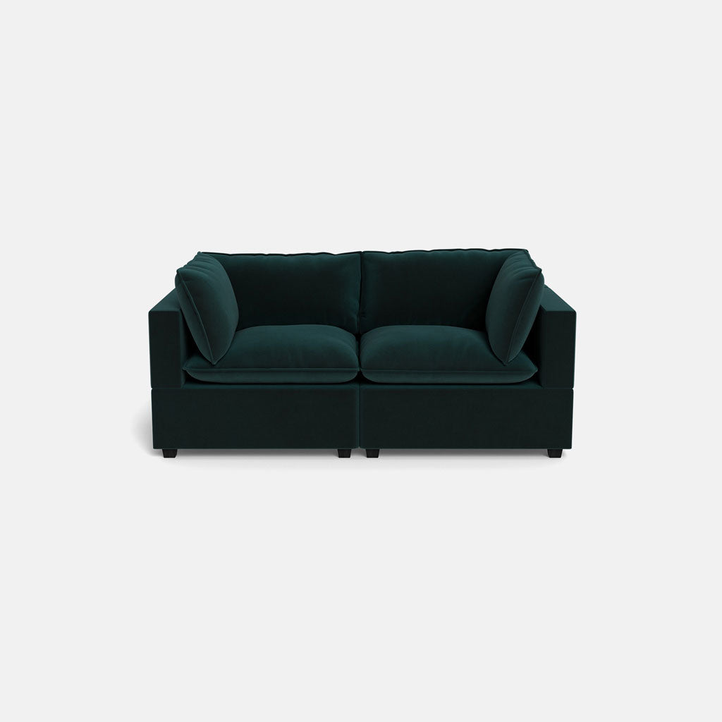 The Kova Pillow Cushion Sofa 86" is a modern dark green velvet sofa with two seat cushions and four back cushions, displayed against a plain light gray background.