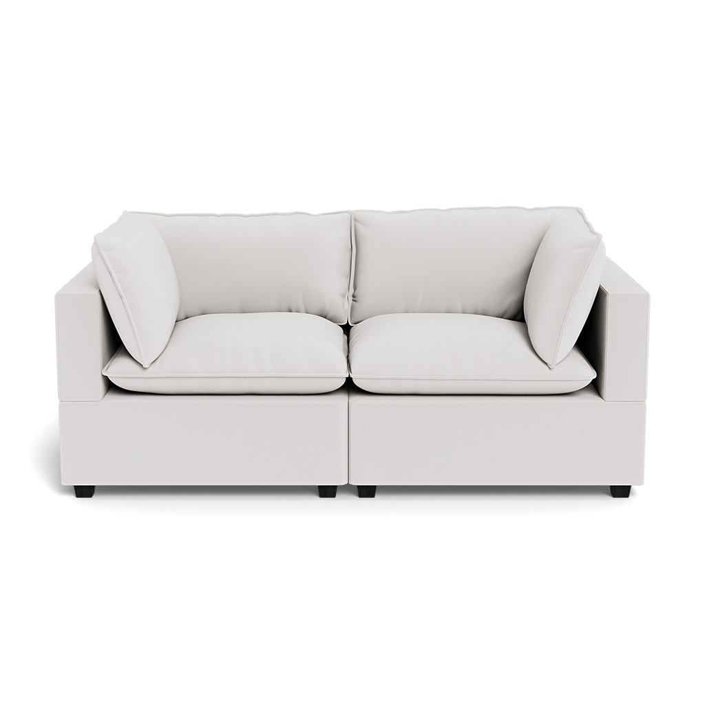 The Kova Pillow Cushion Sofa 86" is a modern, light gray two-seater with square arms and four matching cushions, shown from the front against a black background.