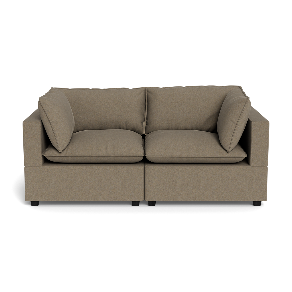 The Kova Pillow Cushion Sofa 86" features a modern, boxy design with light brown upholstery, two seat cushions, two back cushions, and two matching side pillows—displayed against a plain black background.