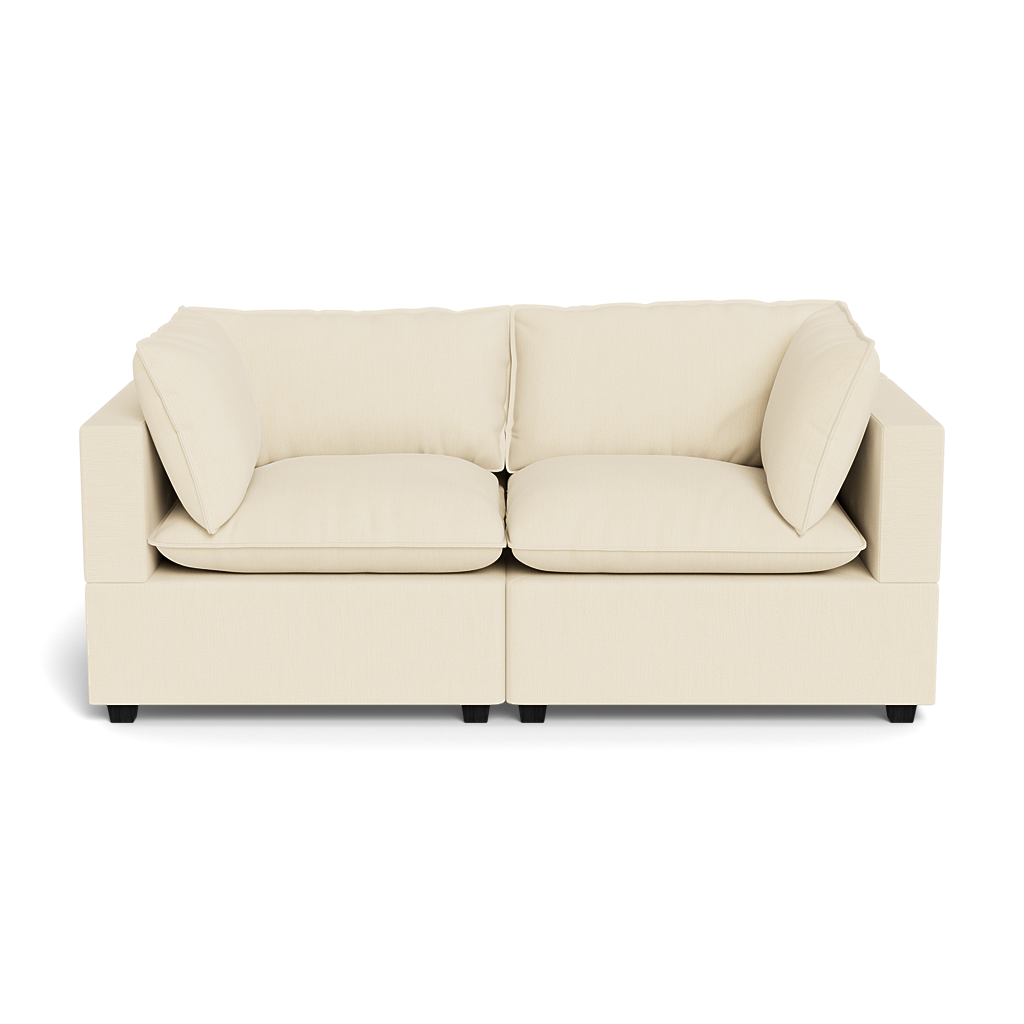 The Kova Pillow Cushion Sofa 86" is a modern, light beige sofa with two seat and back cushions and wide square arms, shown from the front against a plain black background.