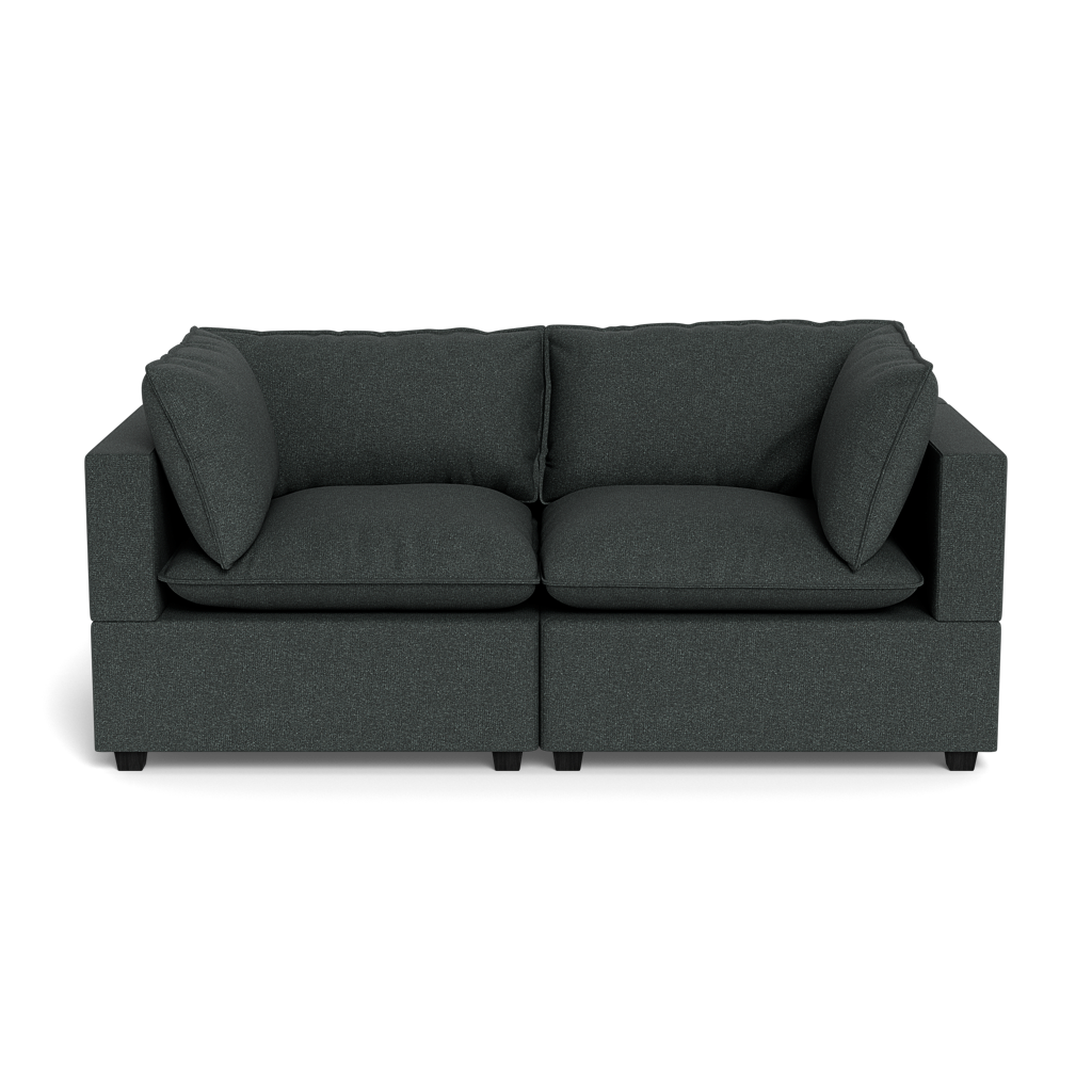 The Kova Pillow Cushion Sofa 86" is a modern dark grey two-seater with square arms and four matching cushions, displayed against a plain black background.