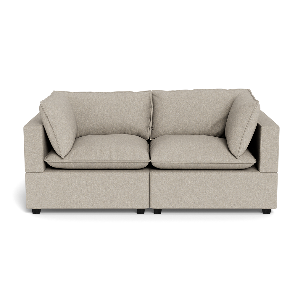 The Kova Pillow Cushion Sofa 86" is a beige, modern two-seater with square arms, plush seat and back cushions, and two matching side pillows, shown from the front against a black background.