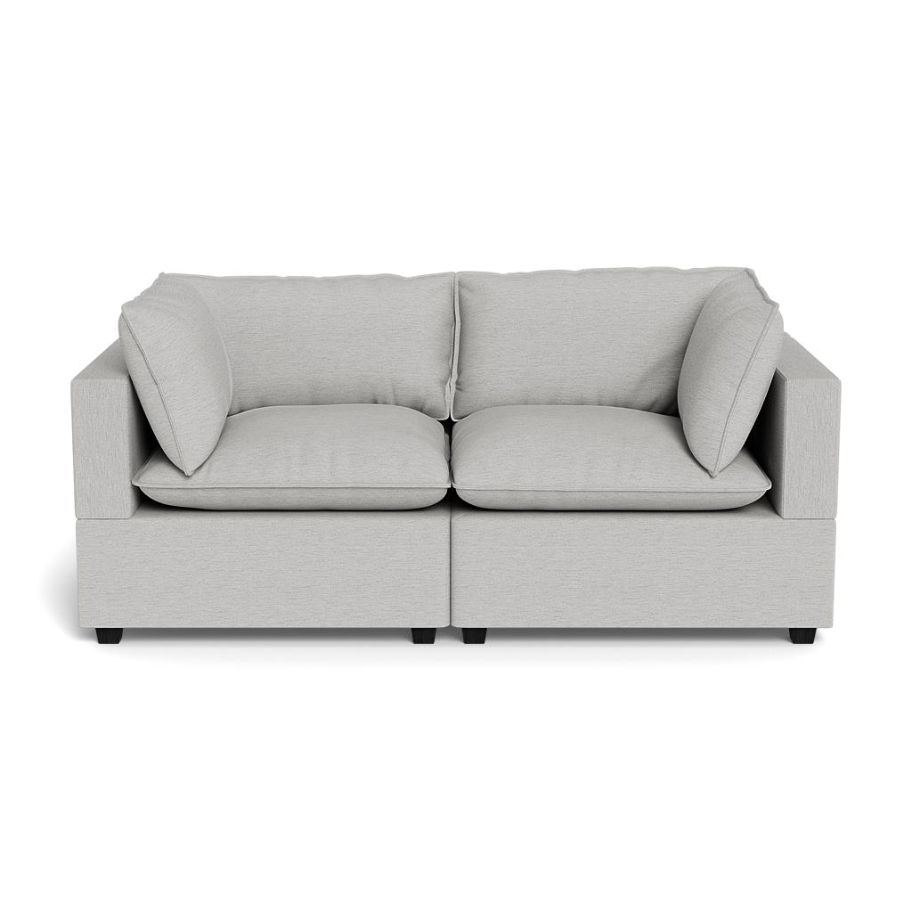 The Kova Pillow Cushion Sofa 86" is a modern light gray two-seater with square armrests, two seat cushions, and two back cushions, displayed against a black background.