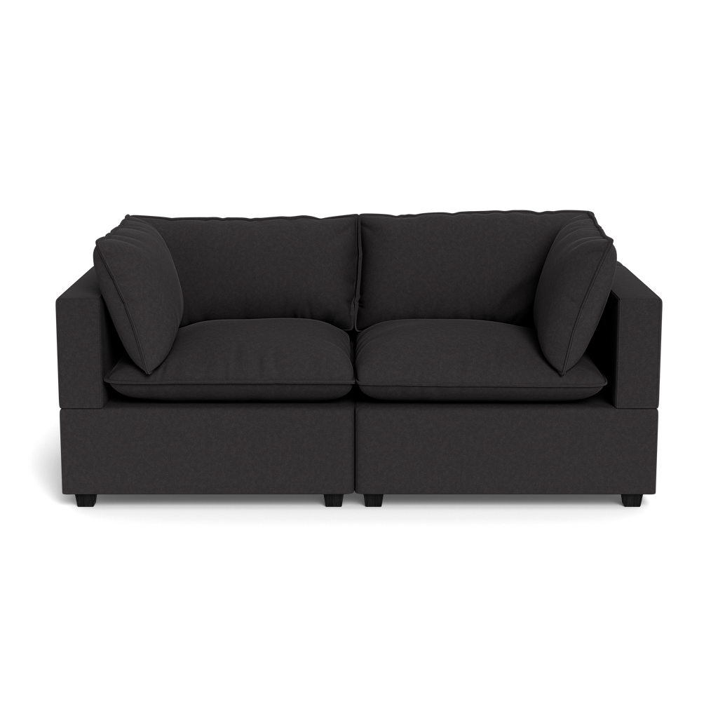 The Kova Pillow Cushion Sofa 86" is a modern dark gray sofa with two seat cushions and two matching side pillows, shown from the front against a plain black background.