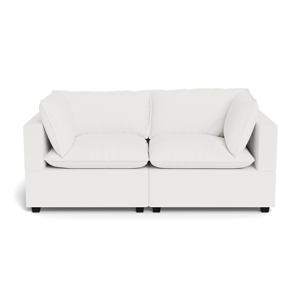 The Kova Pillow Cushion Sofa 86" is a modern white two-seater with square arms and four cushions, displayed against a plain black background.
