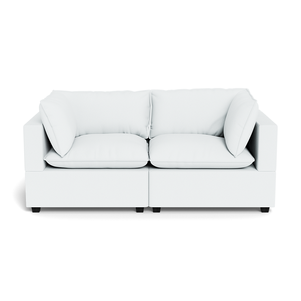 The Kova Pillow Cushion Sofa 86" is a modern white sofa featuring two seat cushions, two back cushions, and four side pillows, shown from the front against a black background.