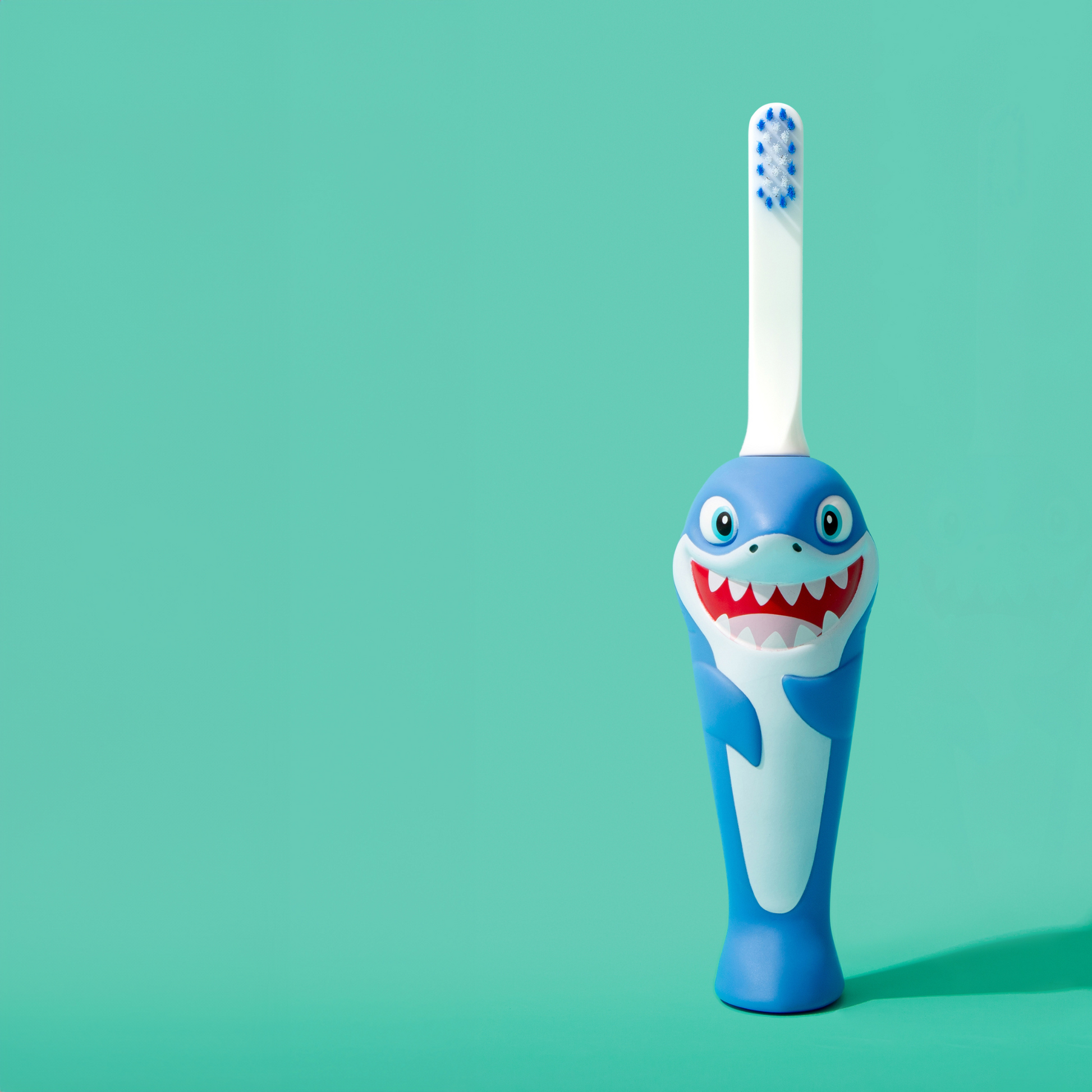 Shark toothbrush for kids with a blue shark-shaped handle and soft bristles from My Store